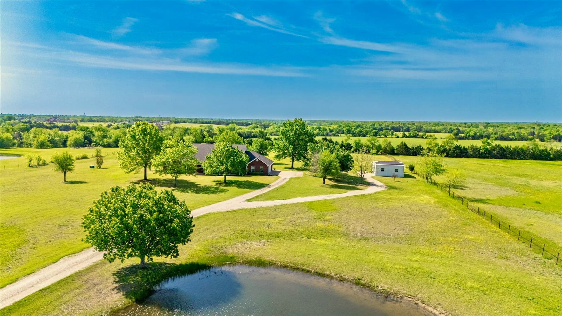 Aerial view of the 7.5 acre property showing home, workshop, and pond